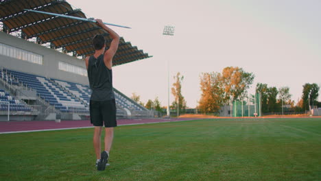 Sportsman-doing-javelin-throw-on-athletic-ground.-Male-athlete-throwing-the-javelin-in-the-olympic-stadium.-Athlete-in-sport-clothes-at-athletic-sport-track-in-professional-stadium